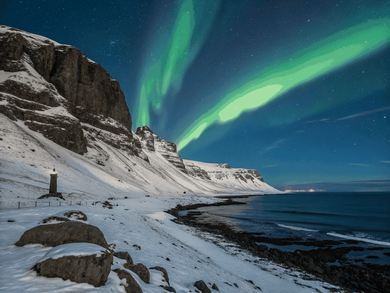 Green aurora arching over black basalt columns
